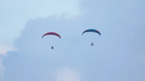 Paramotor pilots maneuvering powered paragliders equipped with propulsion 動画素材 318203129