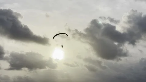 Paramotor powered paraglider flies towards the sun Stock Footage 202773574