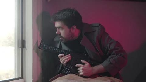 Paranoid man with a gun by window Stock Footage 160177070