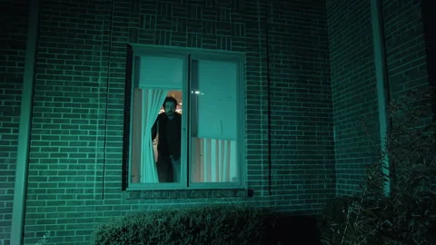 Paranoid man looking out of window Stock Footage 141345903