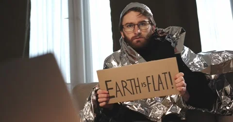 A paranoid, a supporter of pseudoscience holds a sign with a conspiracy slogan. Stock Footage 272252697