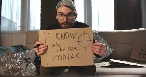 A paranoid, a supporter of pseudoscience holds a sign with a conspiracy slogan. Stock Footage 272252845