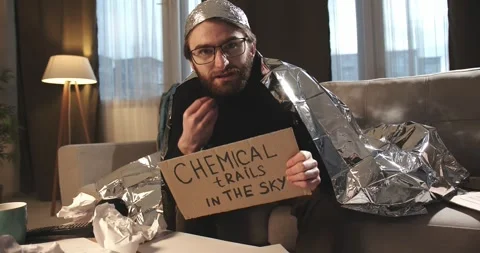 A paranoid, a supporter of pseudoscience holds a sign with a conspiracy slogan. Stock Footage 272253004