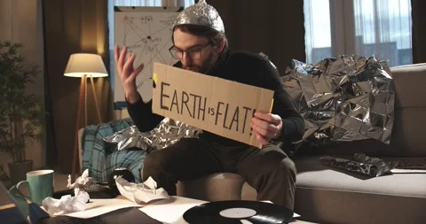 A paranoid, a supporter of pseudoscience holds a sign with a conspiracy slogan. Stock Footage 272253044