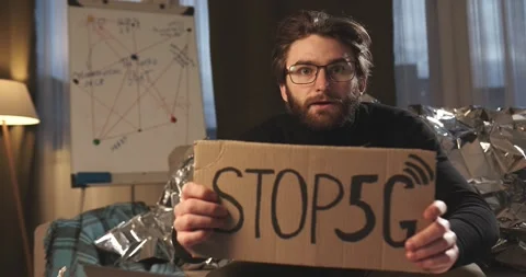 A paranoid, a supporter of pseudoscience holds a sign with a conspiracy slogan. Stock Footage 272253069