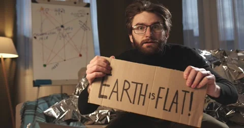 A paranoid, a supporter of pseudoscience holds a sign with a conspiracy slogan. Stock Footage 272253084