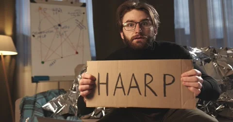 A paranoid, a supporter of pseudoscience holds a sign with a conspiracy slogan. Stock Footage 272253086