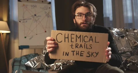 A paranoid, a supporter of pseudoscience holds a sign with a conspiracy slogan. Stock Footage 272253255