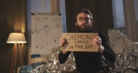 A paranoid, a supporter of pseudoscience holds a sign with a conspiracy slogan. Stock Footage 272253335