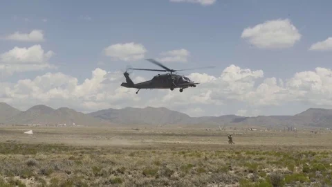 Pararescue men running towards hovering Black Hawk helicopter Stock Footage 85302842