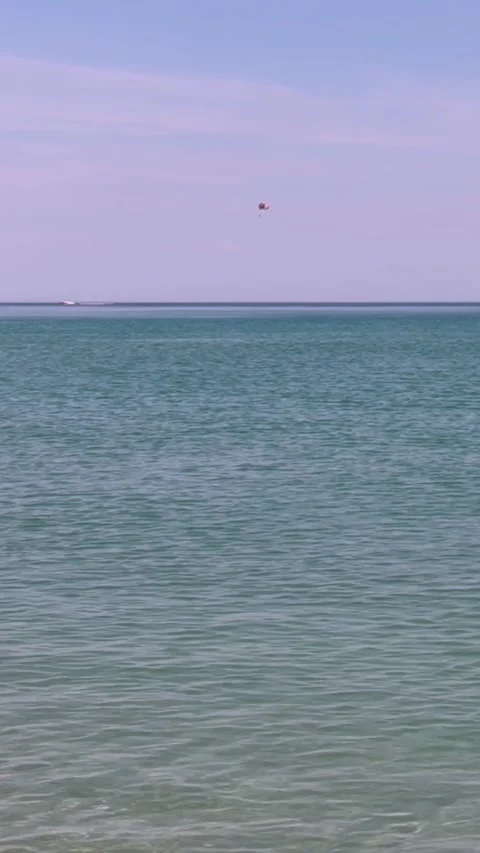 Parasail glides above calm turquoise sea near distant horizon. Recreational Vidéo 337104844