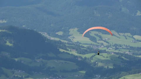 Parasailer soars over Austrian Valley below Stock Footage 148189535
