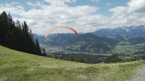 Parasailer takes off to fly over Austrian Alps Valley Stock Footage 148197897