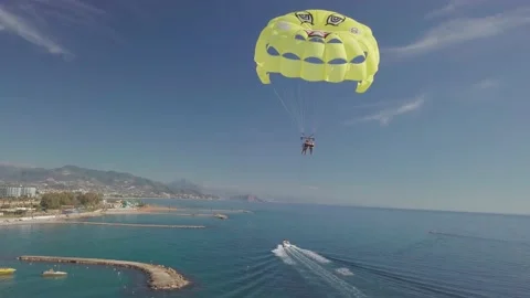 Parasailing is active type of recreation, person on parachute soars through air. Stock Footage 165100883