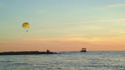 Parasailing is active type of recreation, person on parachute soars through air. Stock Footage 166452474