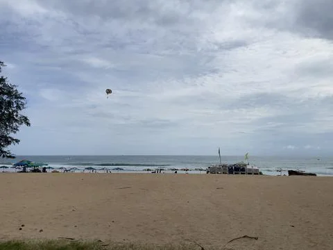 Parasailing on the beach with cloudy sky in the background. Fotos Stock