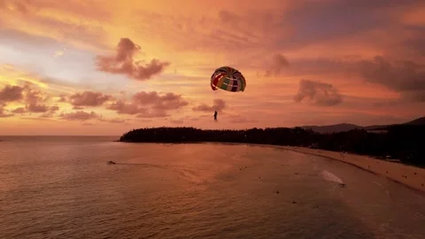 Parasailing at an orange sunset on the beach. Stock Footage 181846148