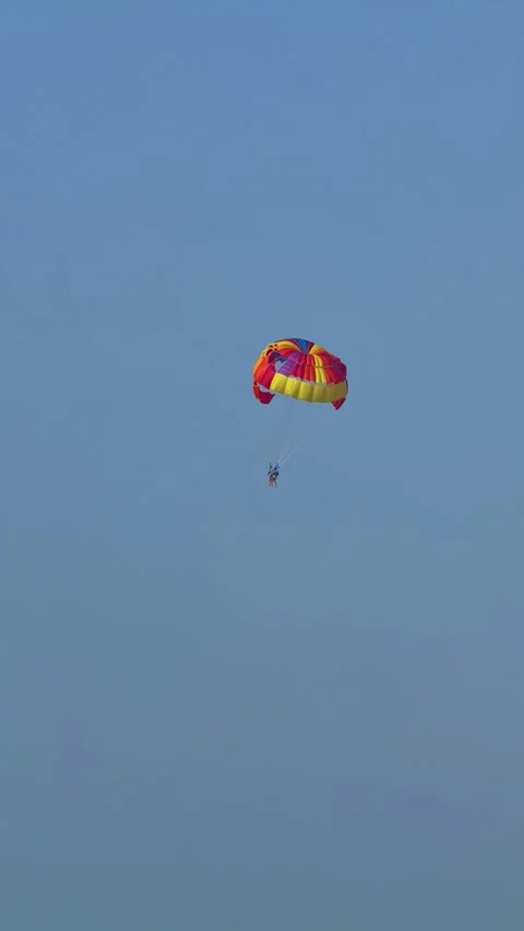 Parasailing over the beach during the day, people relaxing on the beach. High qu Video stock 253100225