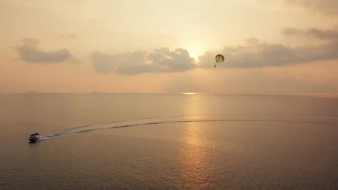 Parasailing over the vast ocean during a stunning sunset Video stock 320063307