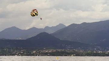 Parasailing Parachute Boating over the beach with alps mountains on the backg Stock Footage 85484472
