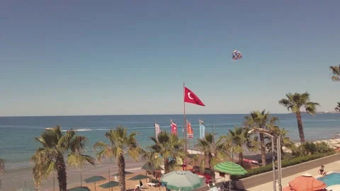 Parasailing parasailing along the sandy beach with palm trees. Blue sky and h Stock Footage 202247784