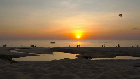 Parasailing passing the sun at Karon beach Phuket Stock Footage 122657084