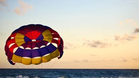 Parasailing provide services to tourists on sky in sunset time. Stockbeeldmateriaal 76246574