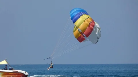 Parasailing - two tourists under bright parachute landing Stock Footage 94099284