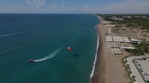 Parasiling drawn by the boat leaves the beach 動画素材 164360237