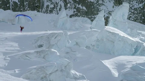Paraskiier flying low over snow-covered mountain Stock Footage 116789019