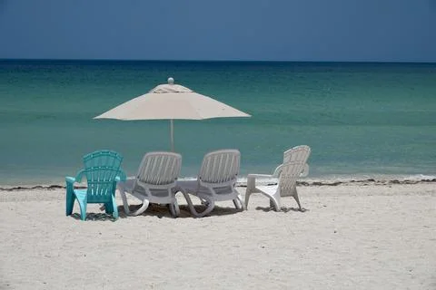 Parasol and sunbeds on empty beach in Progreso by blue ocean in the Caribbean Foto stock