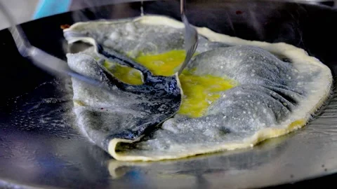 Paratha roti stuffed with egg is being pan-fried in hot oil at a farmer's Vídeo Stock 139729900