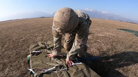 Paratrooper opening package dropped during airborne operation Stock Footage 103258354