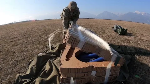 Paratrooper opening package dropped during airborne operation Stock Footage 103258380