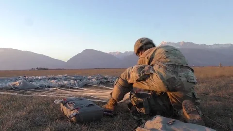 Paratrooper tying cords and packing away parachute 動画素材 84884091