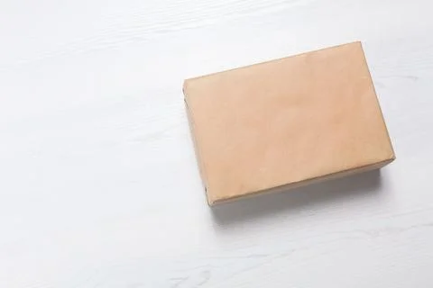 Parcel box wrapped in kraft paper on wooden background with space for text 写真素材