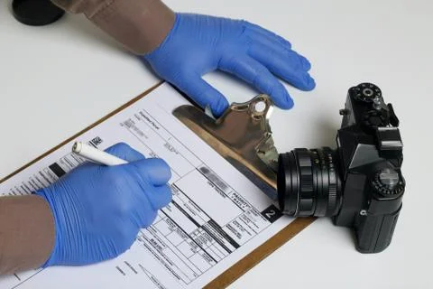 Parcel delivery during self-isolation. A man in rubber gloves signs a package Foto stock