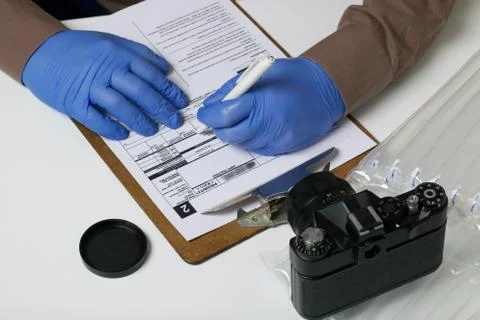 Parcel delivery during self-isolation. A man in rubber gloves signs a package Stock Photos