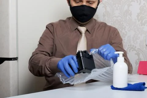 Parcel delivery during self-isolation. A man in rubber gloves and a mask pull 写真素材