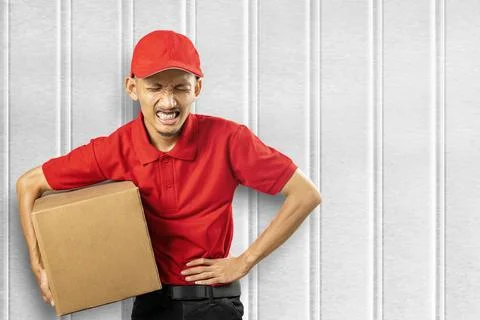 A parcel delivery man with a hat feels a stomachache while carrying a package 스톡 사진