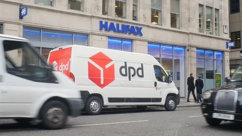 Parcel delivery van in front of a bank office in the financial district of Stock Footage 101927986