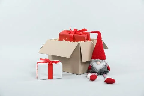 Parcel with gift boxes and decorative dwarf on light background 스톡 사진