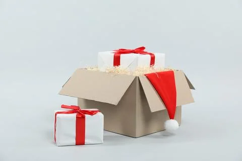 Parcel with gift boxes and Santa hat on light background 스톡 사진