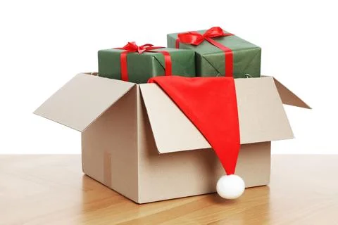 Parcel with gift boxes and Santa hat on wooden table against white background 스톡 사진