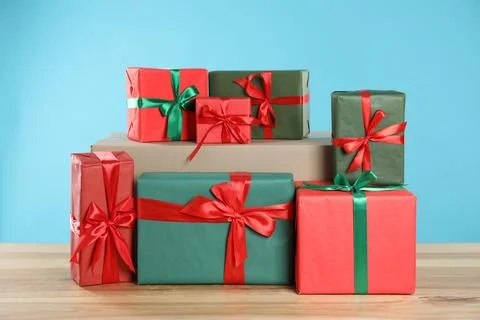 Parcel with gift boxes on wooden table against light blue background 스톡 사진