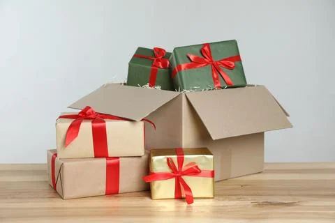 Parcel with gift boxes on wooden table against light background Foto stock