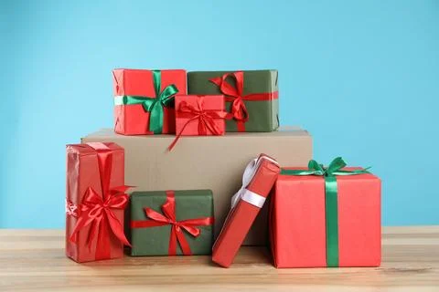 Parcel with gift boxes on wooden table against light blue background 스톡 사진