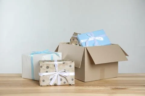 Parcel with gift boxes on wooden table against light background 스톡 사진
