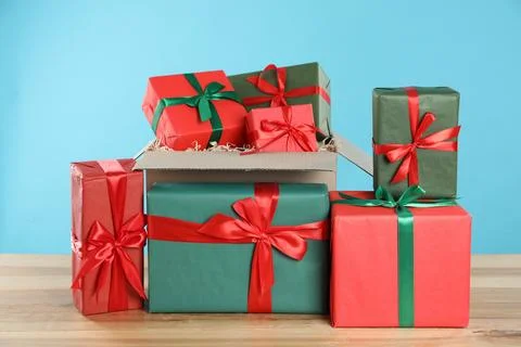 Parcel with gift boxes on wooden table against light blue background 스톡 사진