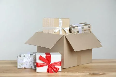 Parcel with gift boxes on wooden table against light background 스톡 사진